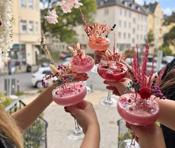 Bunte Cocktails im Freien gehalten von Menschen.