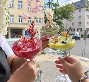 Bunte Getränke mit Dekorationen draußen gehalten.
