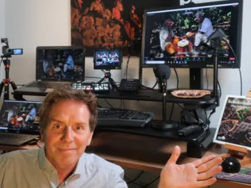 Mann zeigt und erklärt verschiedene Computer und Equipment.