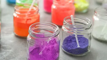 Bunte Pulver in Gläsern auf einem Tisch.
