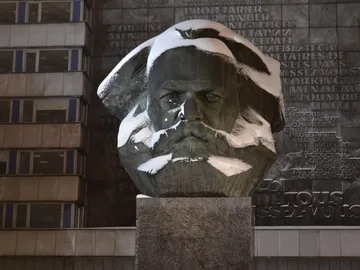 Eine große Statue von Karl Marx, mit Schnee bedeckt.