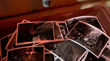 Black and white photos in a darkroom tray.