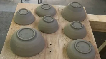 Clay bowls drying on wooden table.