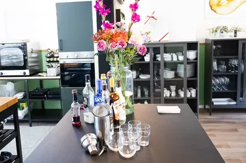 Flaschen auf Küchenarbeitsplatte mit Blumen.