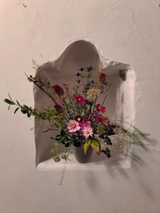 Blumenarrangement in Wandnische, einfache Dekoration.
