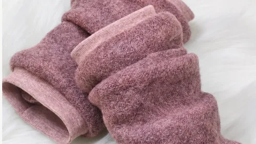 Rosafarbene Wollsocken auf weicher weißer Oberfläche.