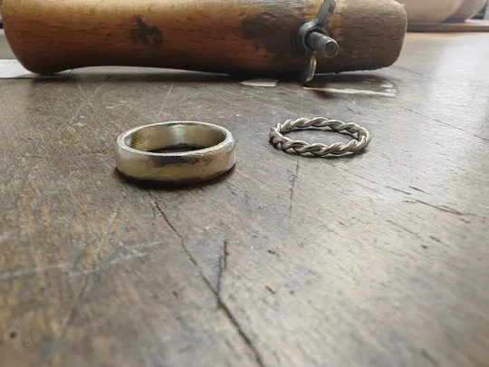 Ringe auf Holzoberfläche, mit Werkzeug daneben.