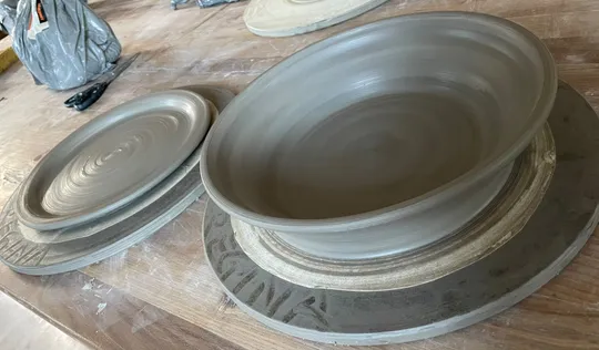 Clay bowls drying on a wooden table.