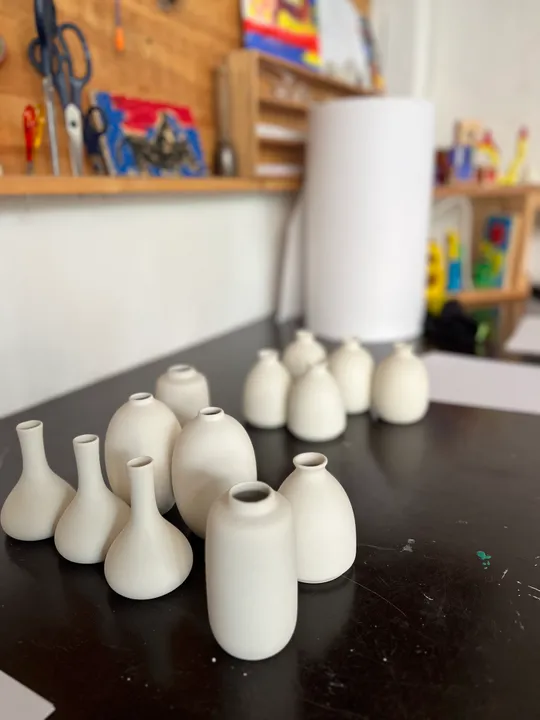 White vases displayed on a black table.