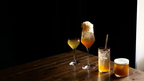 Vier Cocktails auf einem Holztisch arrangiert.