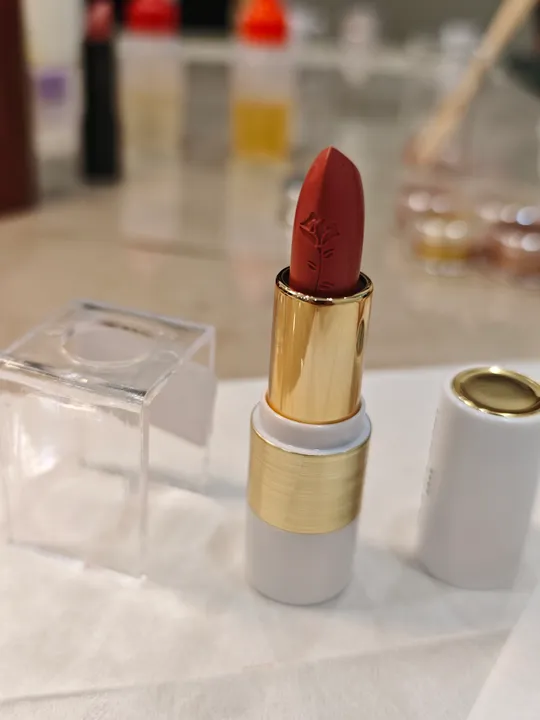 Roter Lippenstift steht auf Tisch.