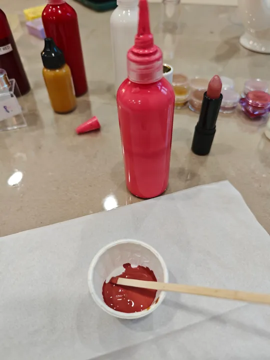 Lippenstiftproduktion auf Tisch mit Flaschen.