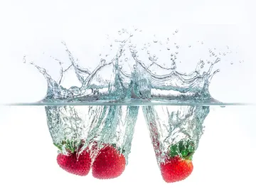 Erdbeeren spritzen ins Wasser und erzeugen Wellen.