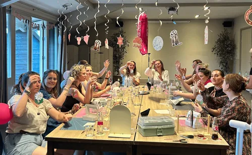 Frauen basteln an dekoriertem Partytisch.
