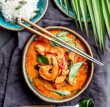 Garnelen in scharfem Curry mit Reis oben.