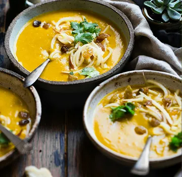 Bowls of soup with noodles and parsley.