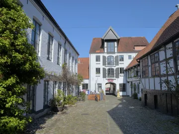 Hübscher Innenhof mit historischen Gebäuden und blauem Himmel.