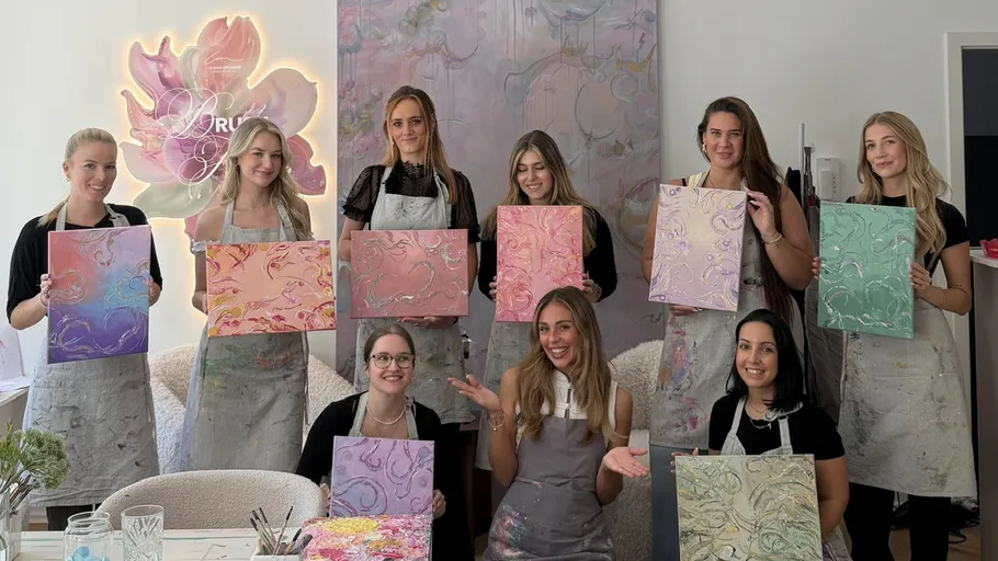 Frauen zeigen Gemälde im Kunststudio.