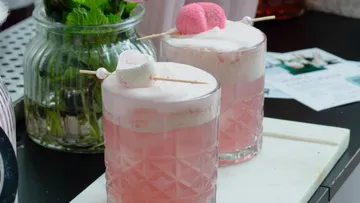 Rosa Getränke mit Marshmallows auf Tisch.