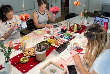Women crafting at a decorated table.