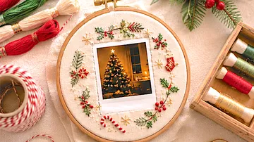 Embroidery hoop with Christmas photo surrounded by threads.