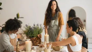 Personen basteln am Tisch mit Pflanzen.