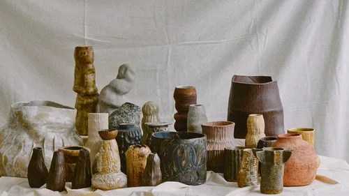 Handcrafted vases displayed on draped fabric.