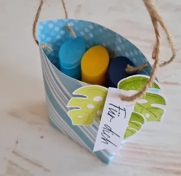Gift bag with colorful bottles inside.