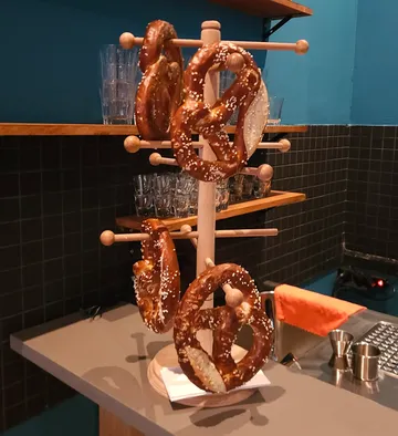Brezeln hängen an Holzständer in Küche.
