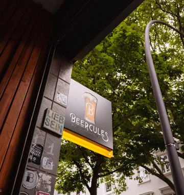 Bar sign under trees in street setting