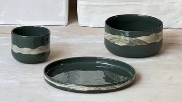 Green ceramic bowls and plate on table.
