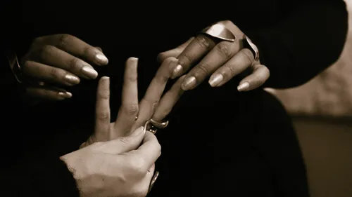 Hände setzen Ringe auf Finger.