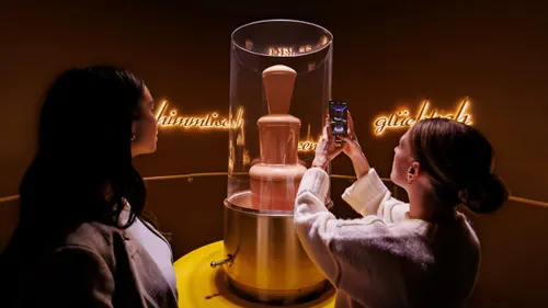 Zwei Frauen bewundern einen Schokoladenbrunnen.