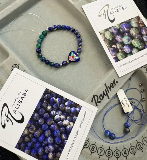 Beaded bracelet and cards on tray.