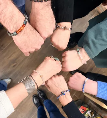 Hands with bracelets in a circle.
