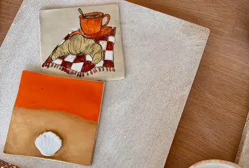 Tiles with food and shell designs, table setting.