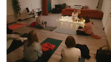 People meditating on mats with candles.