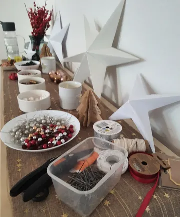Tisch mit Bastelmaterialien und Papiersternen dekoriert.