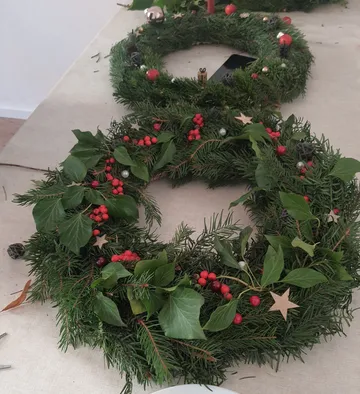 Christmas wreath with red berries on a table.