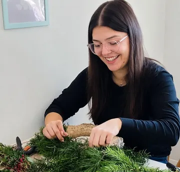 Woman creating a wreath at home.