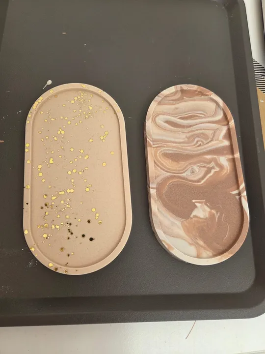 Two decorative trays on a black surface.
