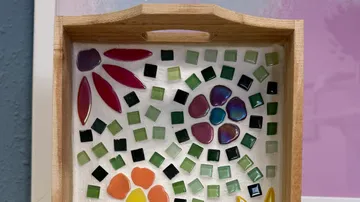 Holztablett mit bunten Mosaikfliesen.