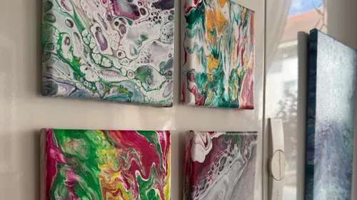 Colorful abstract paintings hanging on a wall.