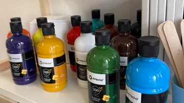 Bottles of acrylic paint on a shelf.