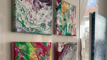 Bunte abstrakte Gemälde an weißer Wand.