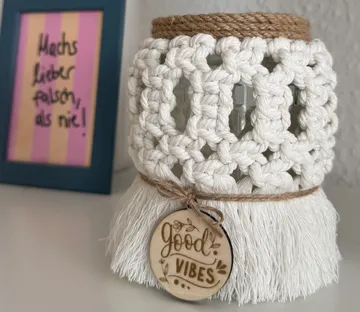 Häkelglas mit "Good Vibes"-Anhänger drinnen angezeigt.