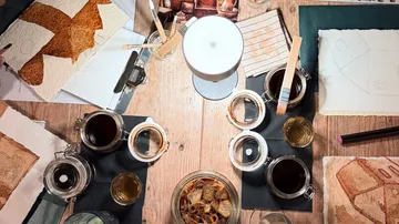 Art supplies arranged on wooden table.
