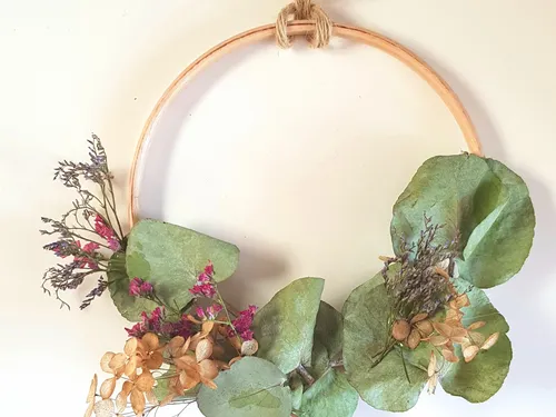 Circular wreath with dried flowers on wall