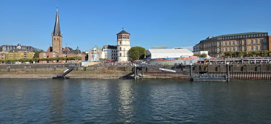 Riverside view of historic buildings and church.