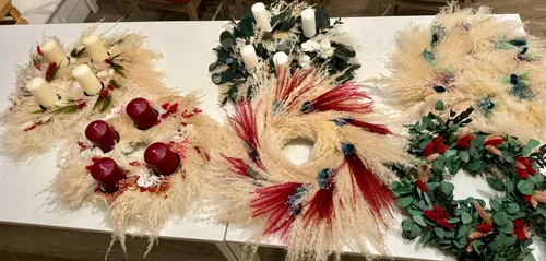 Decorative wreaths and candles on a table.